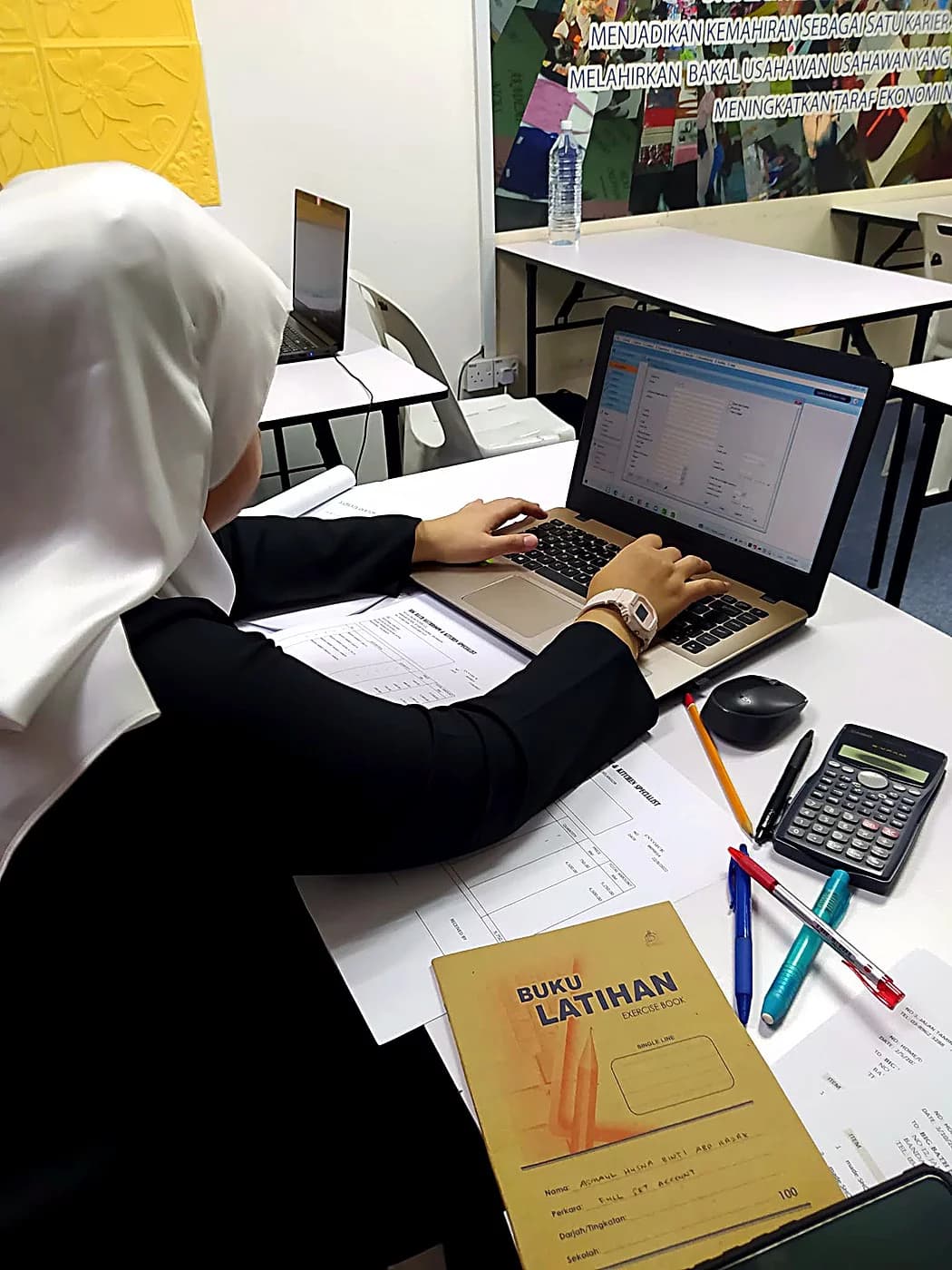 Student completing a full set account exercise on a laptop