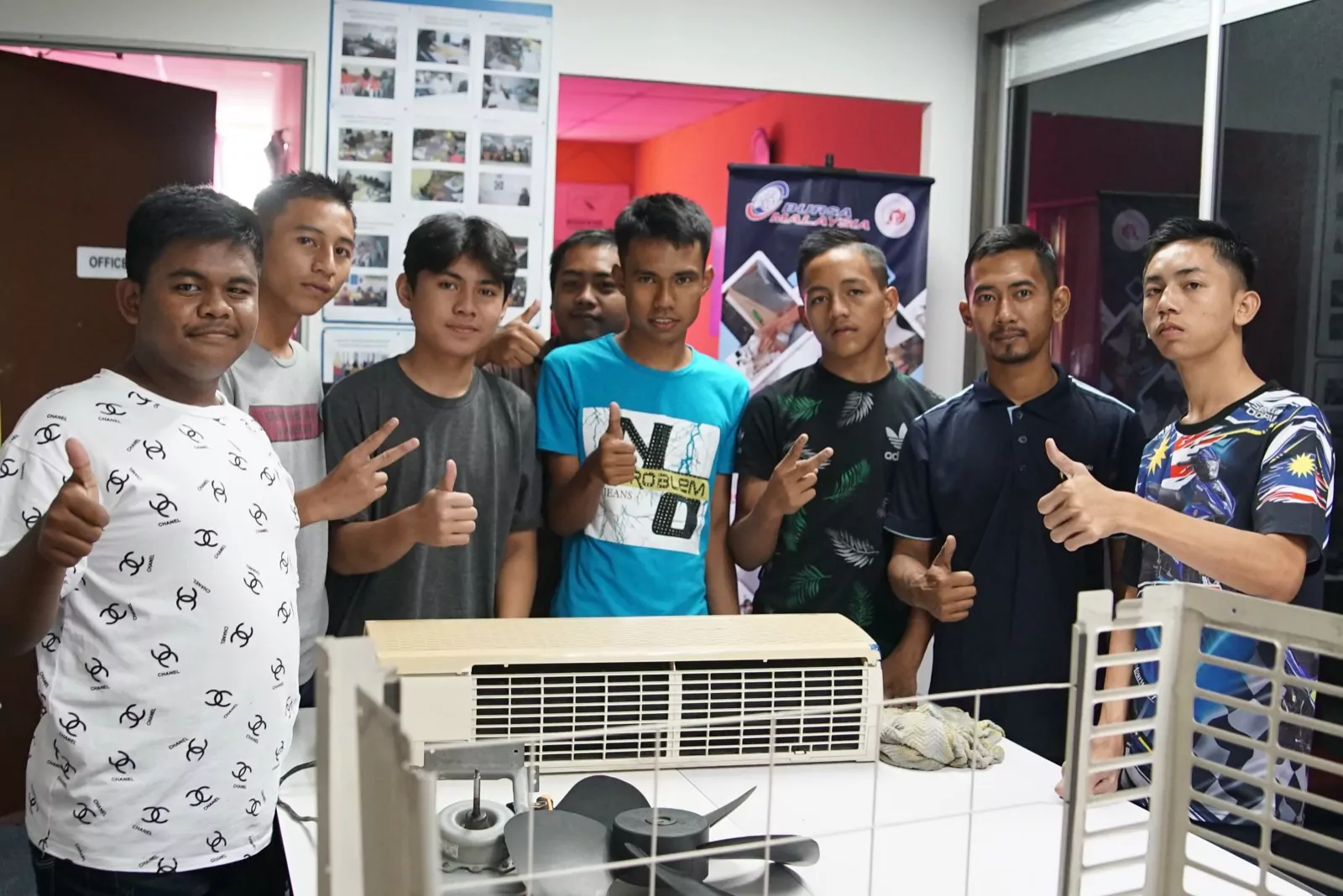 An air-conditioner repair cohort standing behind their unit