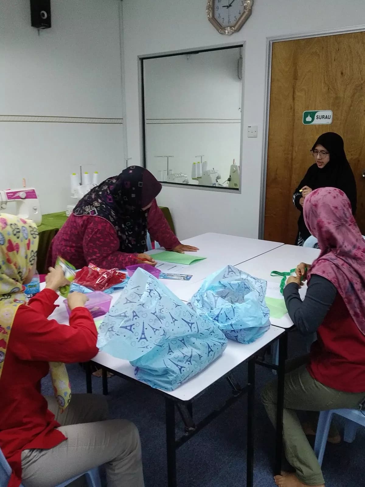 Students cutting and preparing printed fabric at a work table