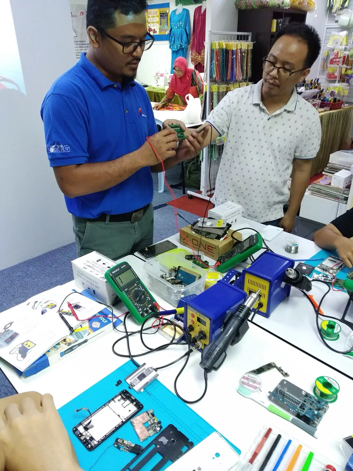 An instructor demonstrating a repair to a student