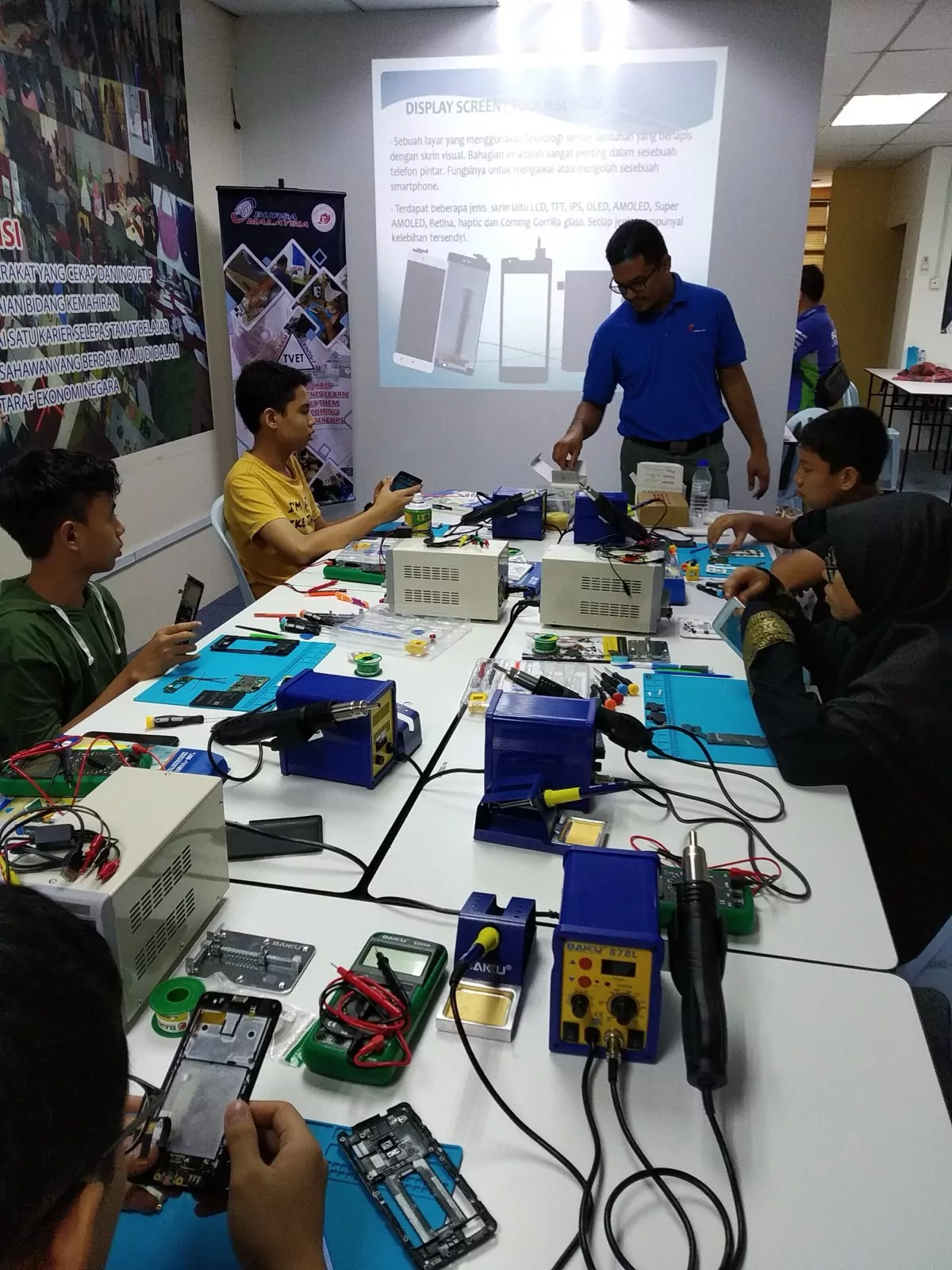 A full phone repair class working at soldering stations