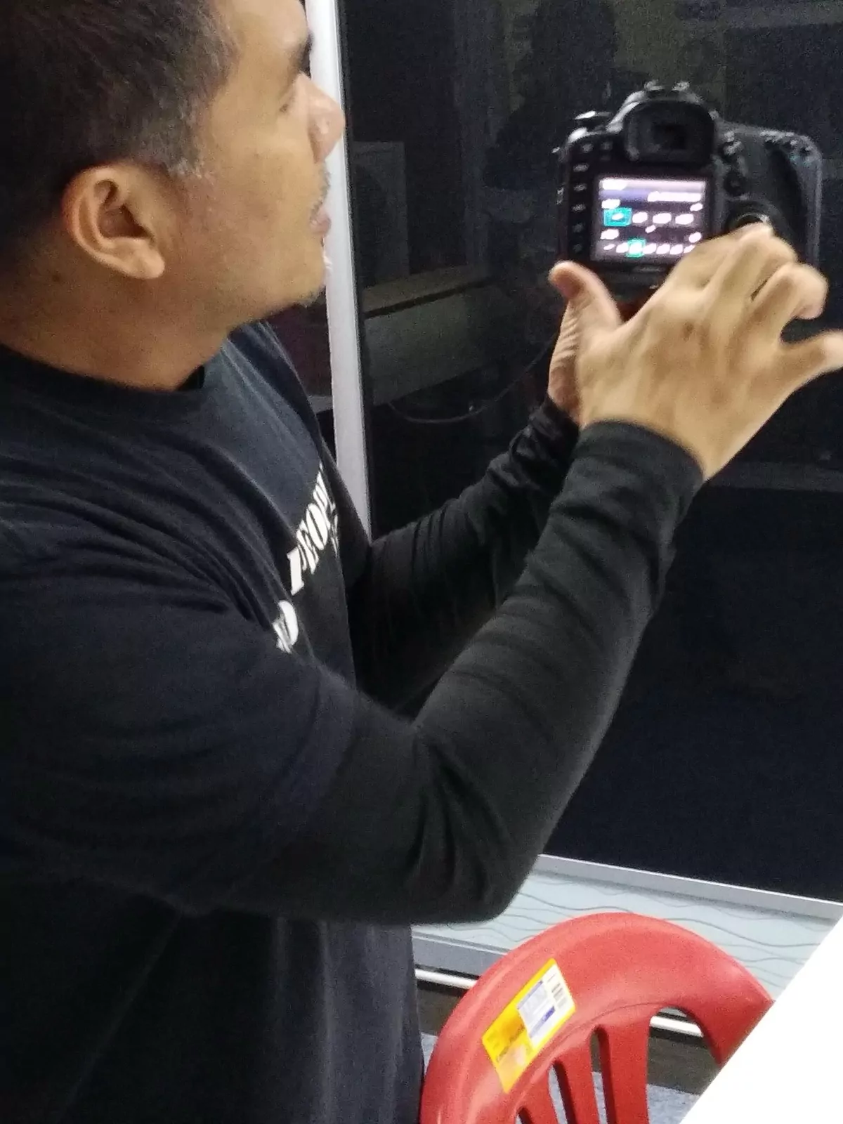 A student checking a shot on the back of a camera