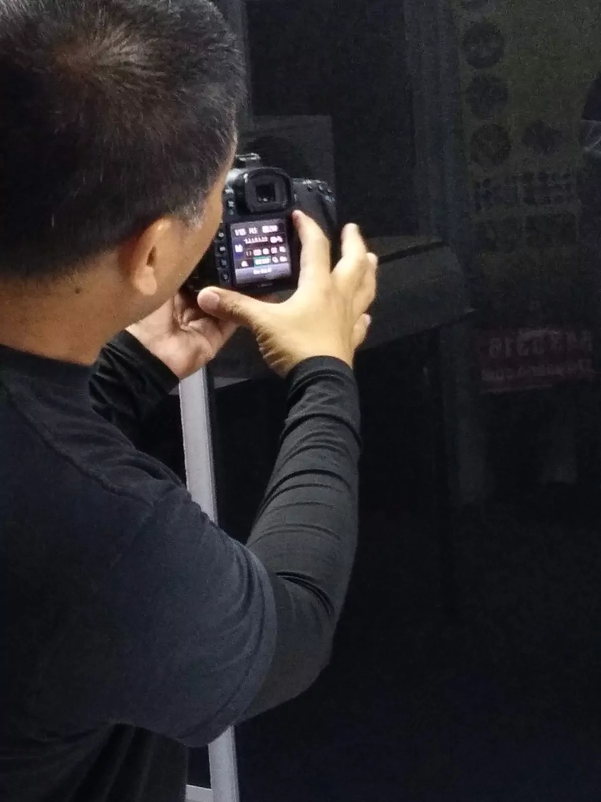 A student framing a shot through a DSLR viewfinder