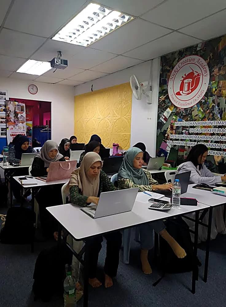 Students working on laptops in the academy's classroom
