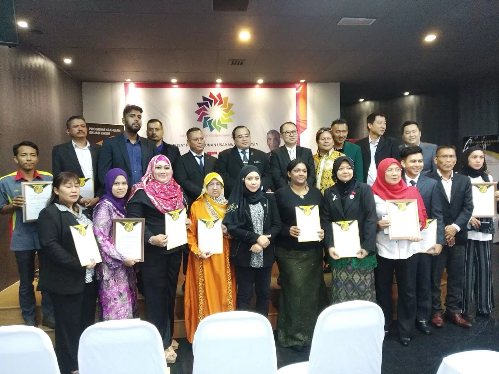 Academy graduates with their certificates at a ceremony