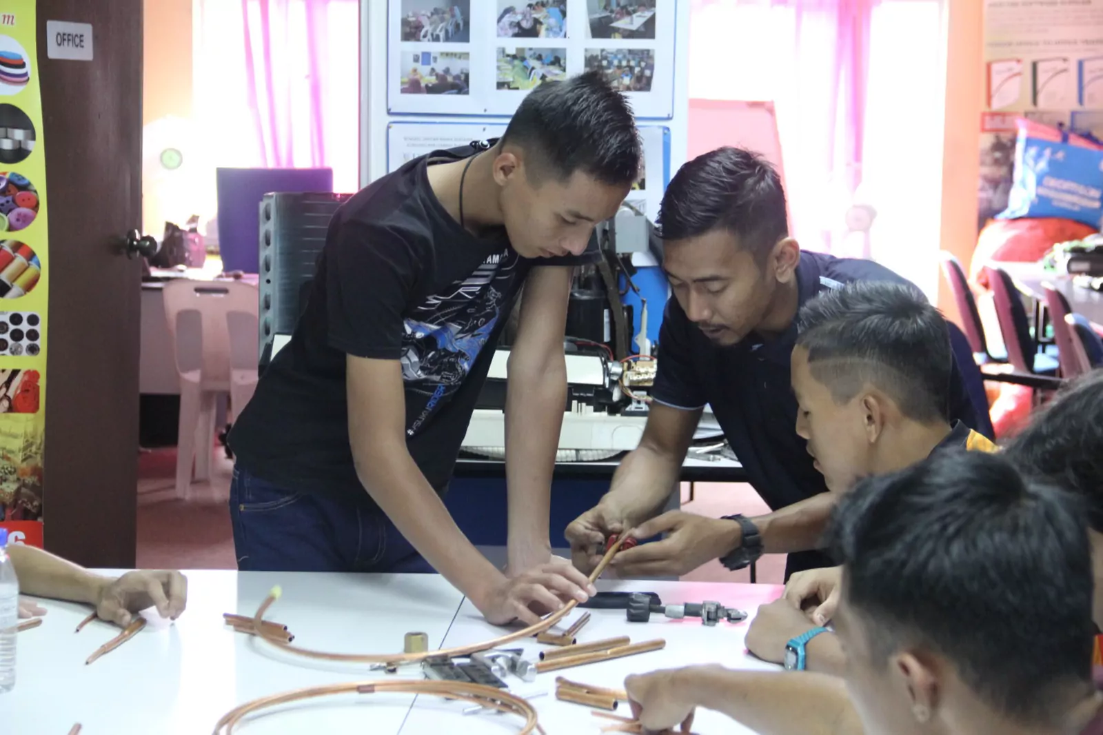Trainees soldering copper pipework at the workbench