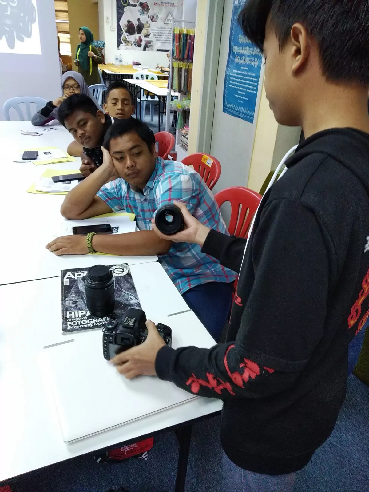 Students gathered around a DSLR during a photography class