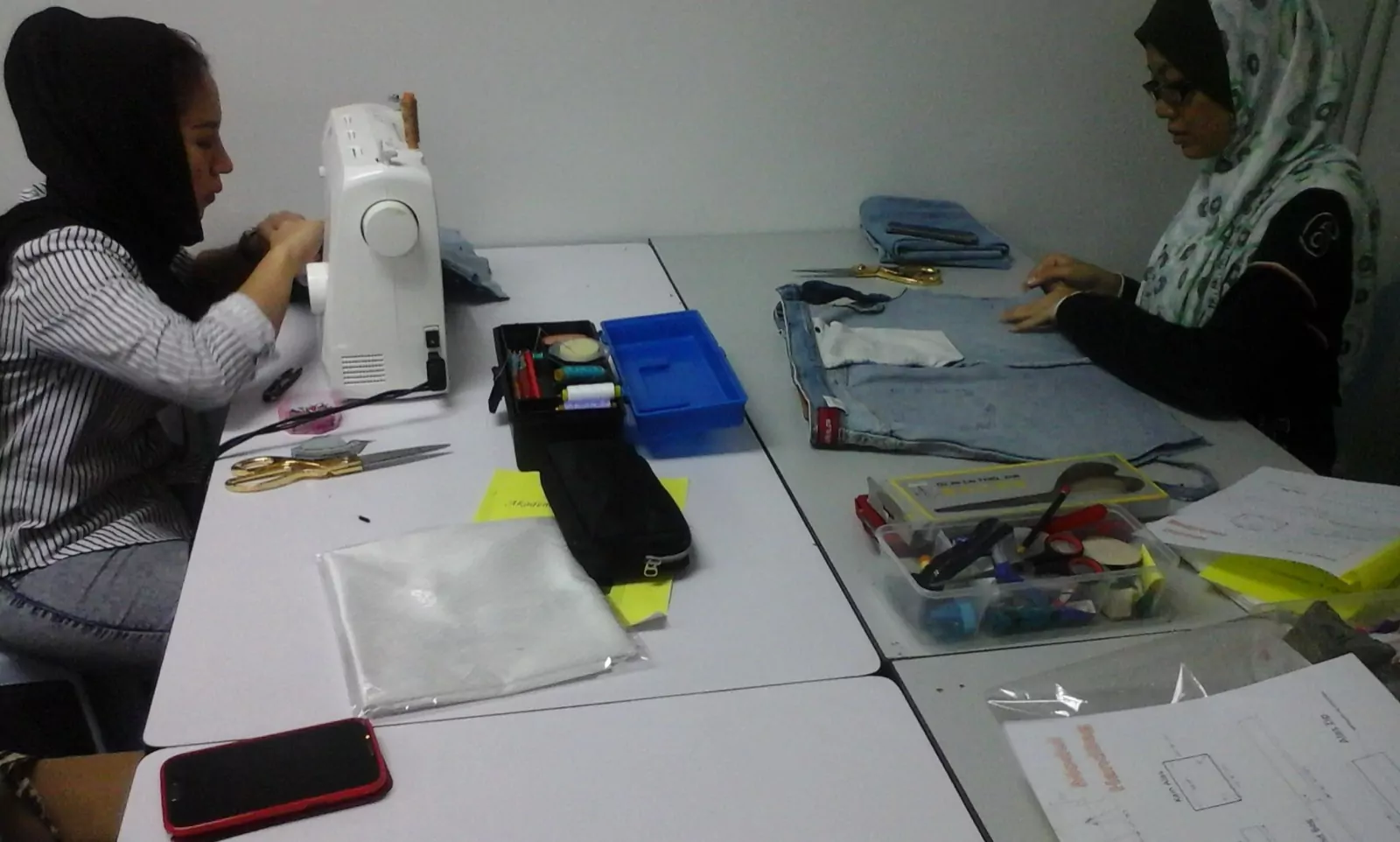 A student sewing a garment on the machine during class